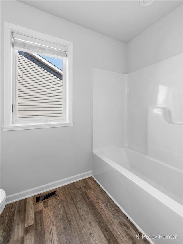 full bathroom featuring visible vents, toilet, shower / tub combination, wood finished floors, and baseboards