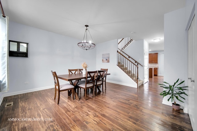 dining room featuring visible vents, dark wood finished floors, baseboards, and stairs