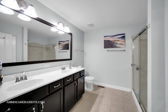 bathroom featuring double vanity, a stall shower, a sink, and visible vents