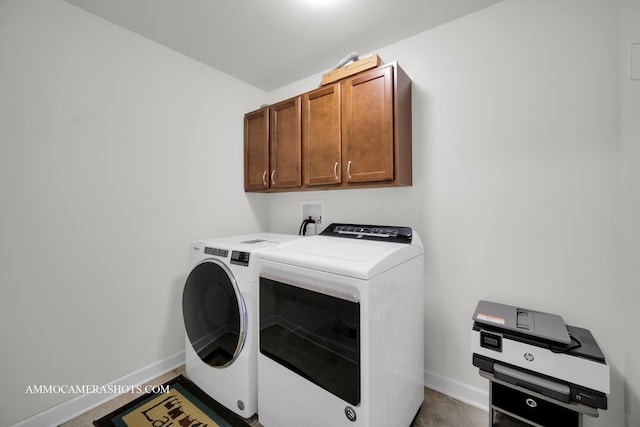 washroom featuring baseboards, cabinet space, and washer and dryer