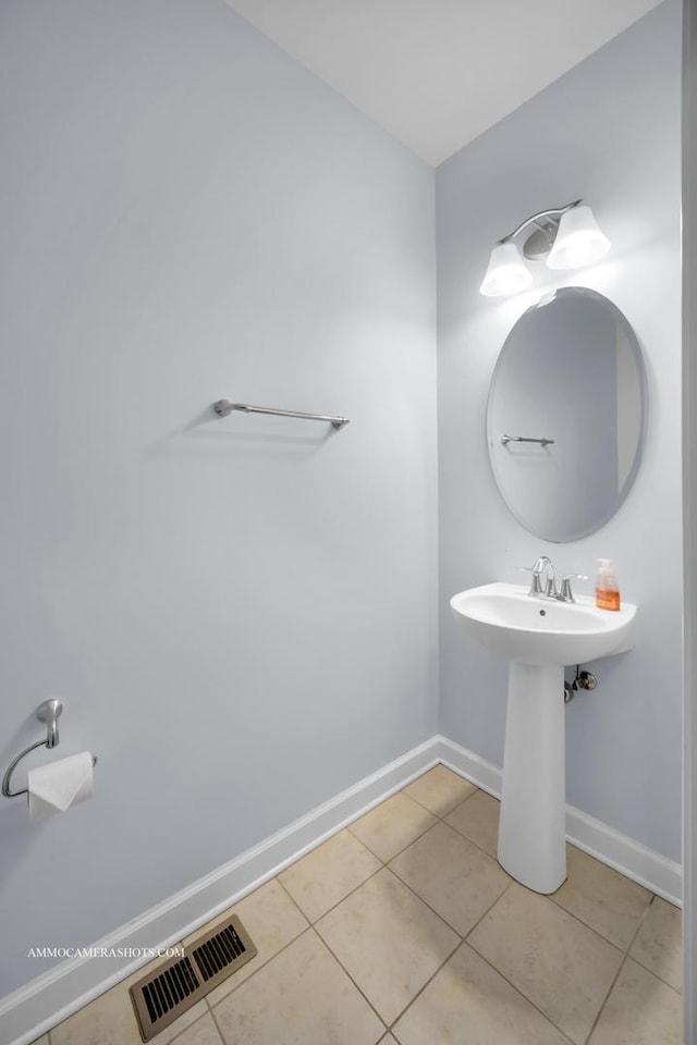 bathroom featuring a sink, tile patterned flooring, visible vents, and baseboards