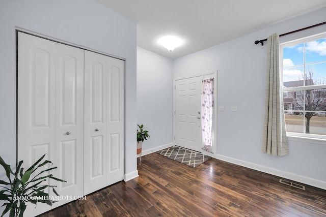 foyer with dark wood-style floors, visible vents, and baseboards