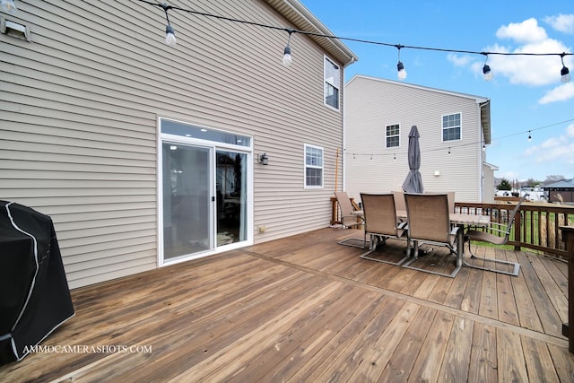 wooden terrace with grilling area and outdoor dining area