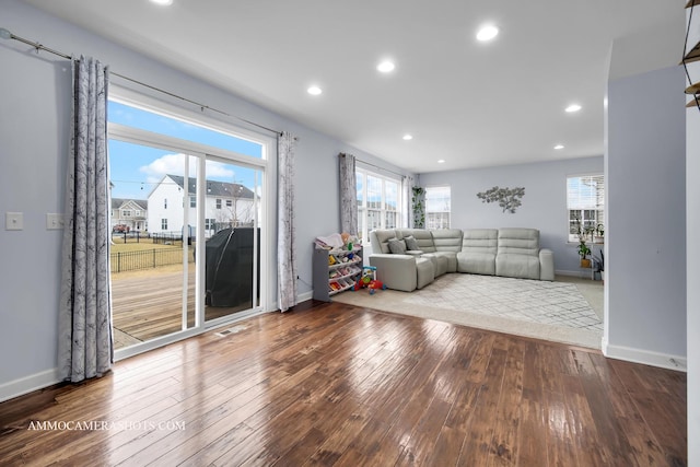 unfurnished living room with baseboards, hardwood / wood-style floors, and recessed lighting