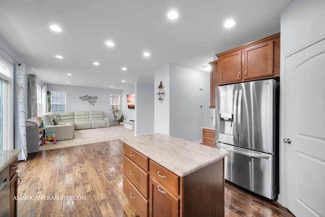 kitchen featuring dark wood-style floors, light stone counters, recessed lighting, a kitchen island, and stainless steel fridge with ice dispenser