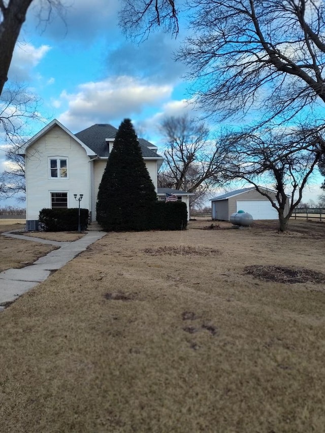 view of side of property featuring a garage and a yard