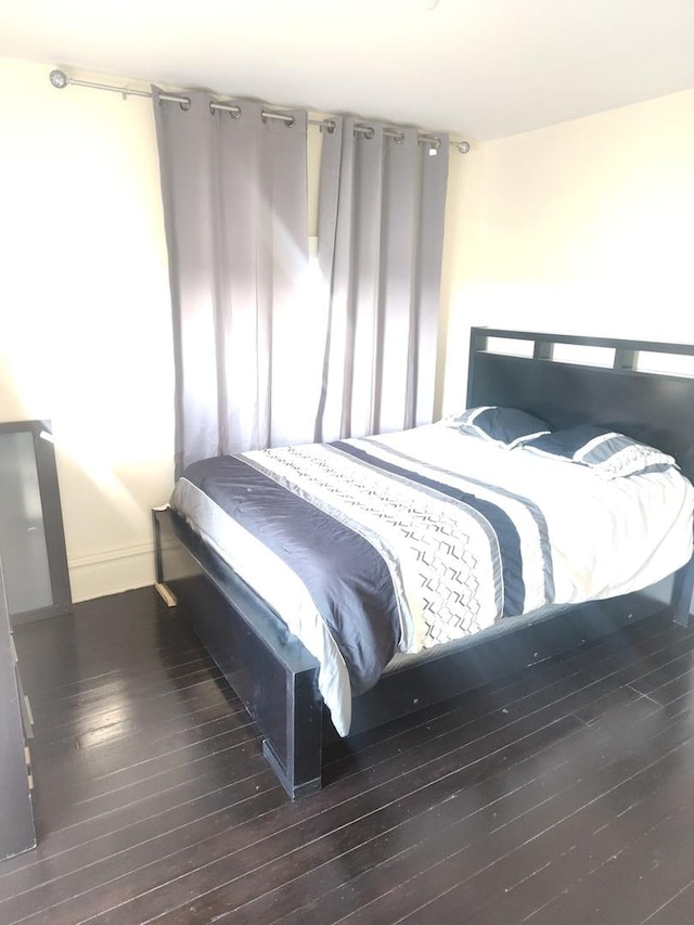 bedroom featuring wood-type flooring and baseboards