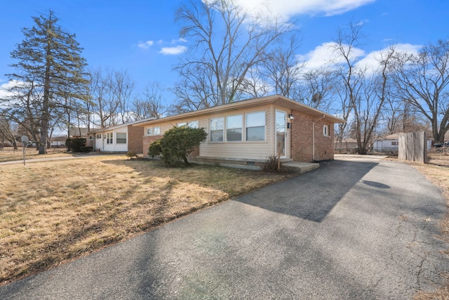 view of front of house with driveway, crawl space, a front lawn, and brick siding