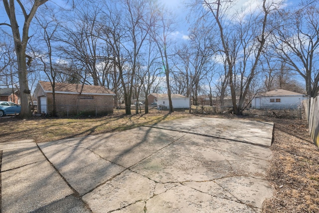 view of yard with concrete driveway and fence