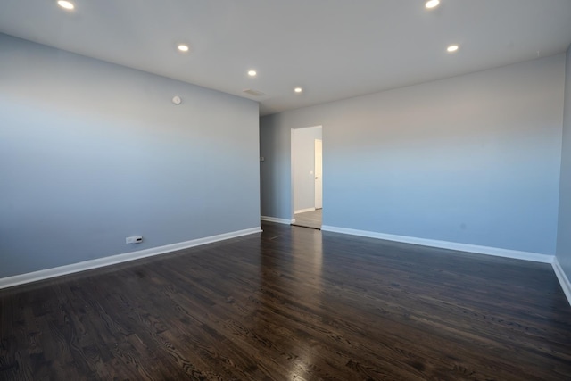 unfurnished room featuring recessed lighting, dark wood-style flooring, and baseboards