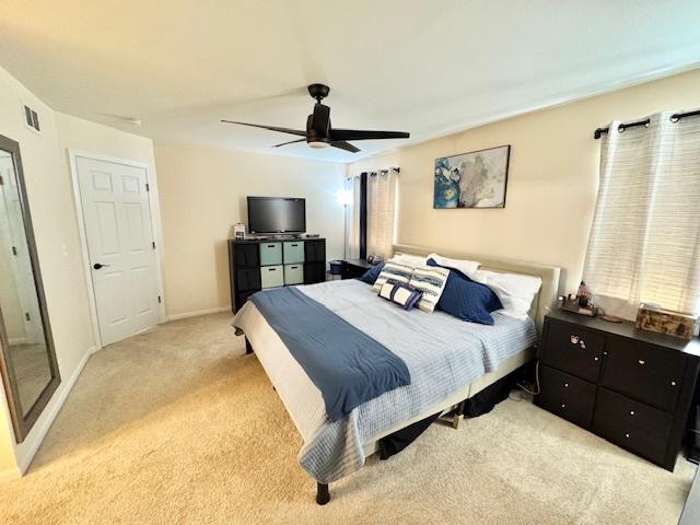 bedroom featuring light colored carpet, visible vents, ceiling fan, and baseboards