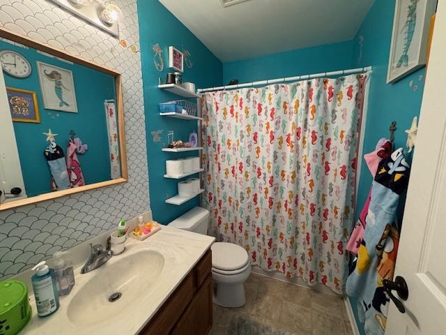 full bath with toilet, a shower with shower curtain, and vanity