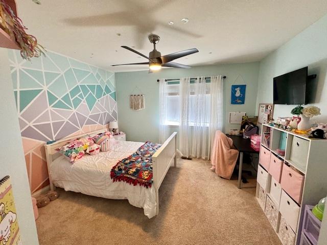 bedroom featuring light colored carpet and ceiling fan