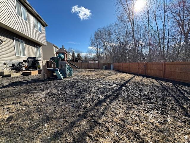 view of yard with a playground and a fenced backyard