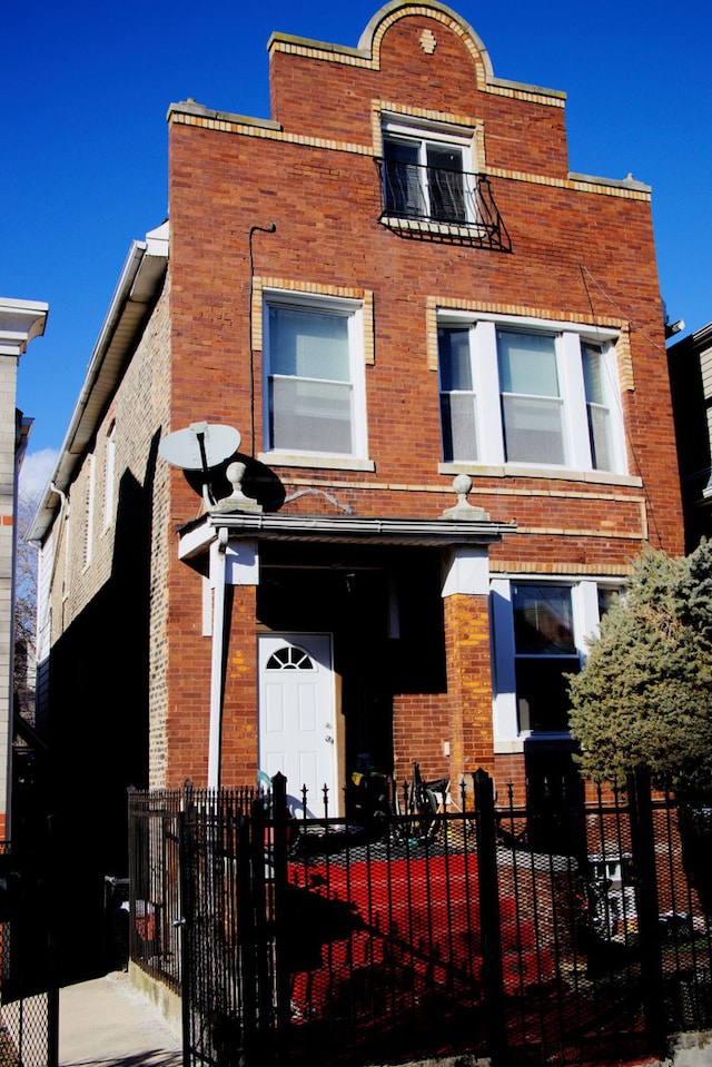 view of front facade with brick siding and a fenced front yard