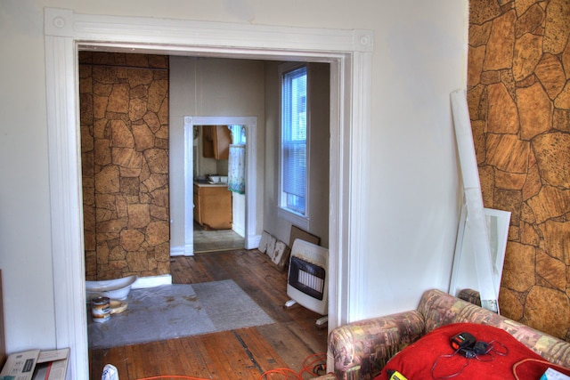 interior space featuring heating unit, baseboards, and hardwood / wood-style floors