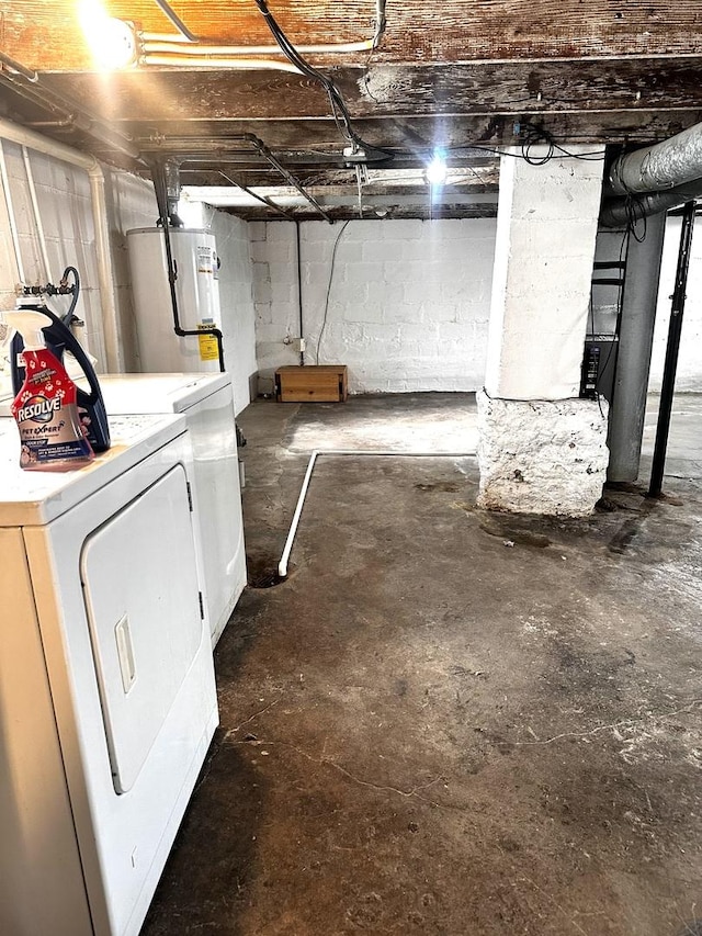 unfinished below grade area featuring gas water heater and washing machine and clothes dryer