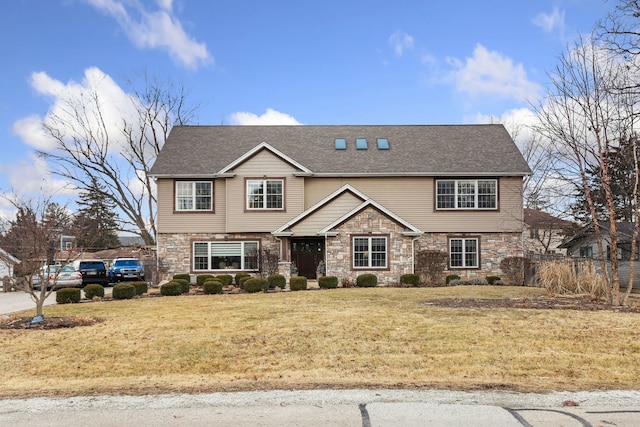 view of front of home featuring a front yard, stone siding, and roof with shingles