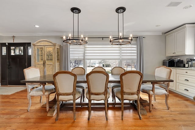 dining space featuring recessed lighting, visible vents, an inviting chandelier, ornamental molding, and light wood-type flooring