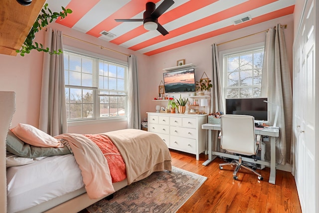 bedroom featuring light wood-style flooring, multiple windows, and visible vents