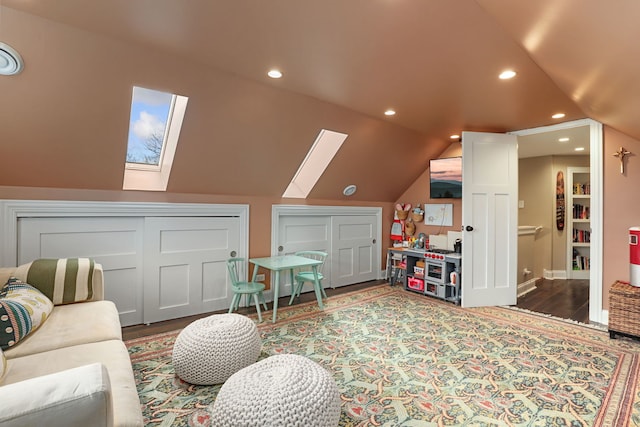 interior space with lofted ceiling with skylight, wood finished floors, and recessed lighting