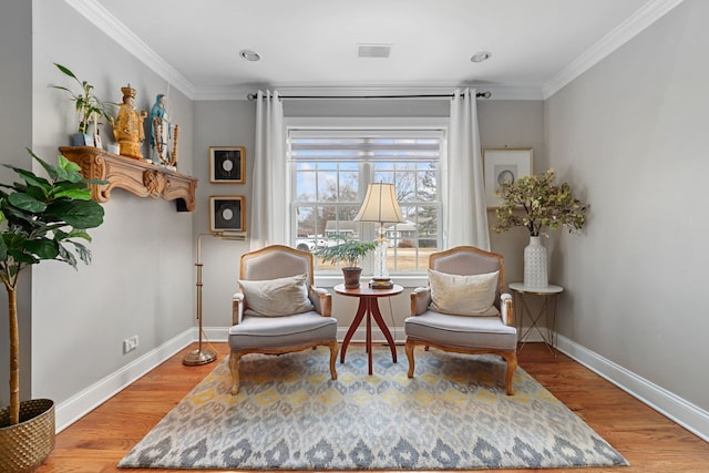 sitting room featuring baseboards, ornamental molding, and light wood-style floors