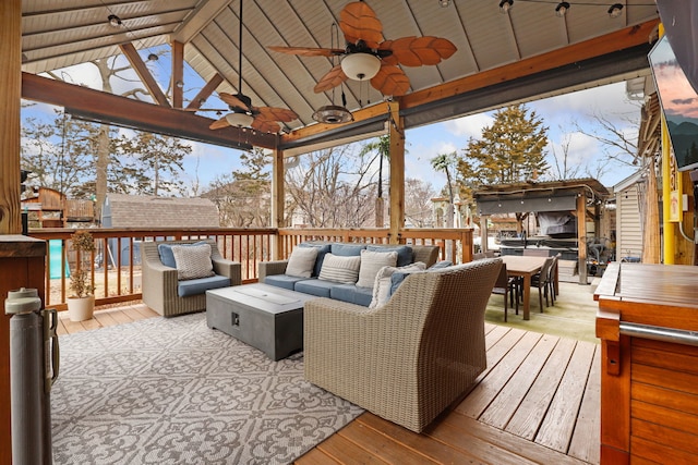 wooden deck with an outdoor living space and a ceiling fan