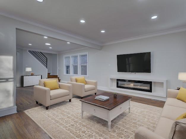 living area featuring crown molding, recessed lighting, a glass covered fireplace, wood finished floors, and stairs