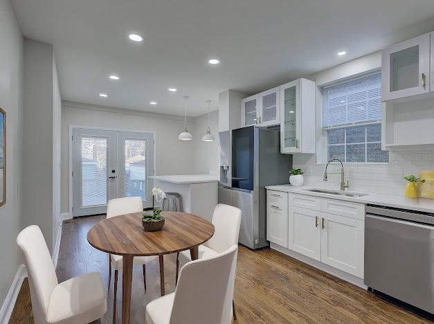 kitchen with appliances with stainless steel finishes, dark wood finished floors, a sink, and french doors