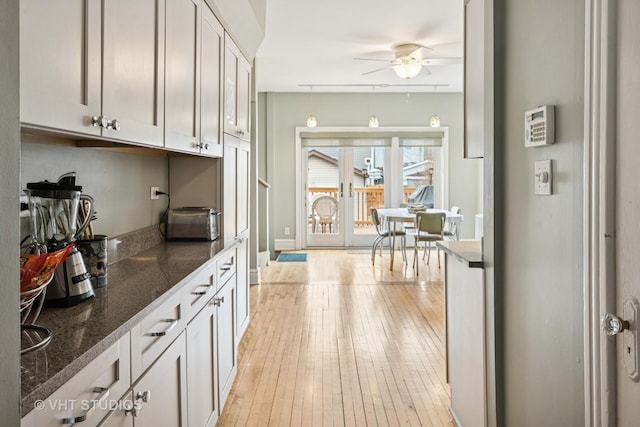 kitchen with ceiling fan, white cabinetry, and light wood-style floors