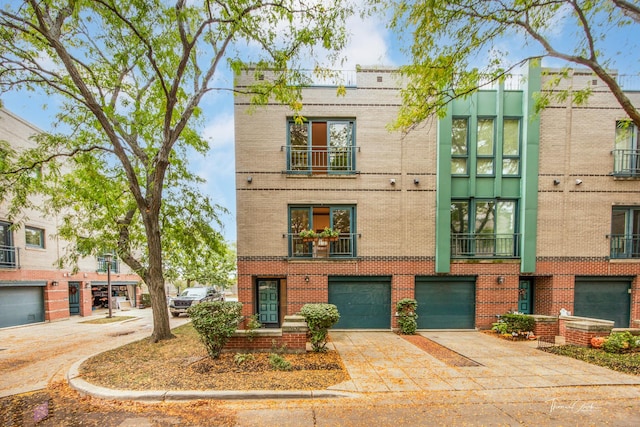 multi unit property featuring driveway, brick siding, and an attached garage