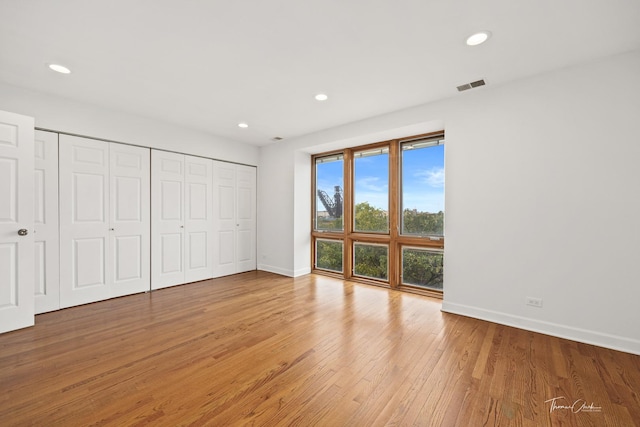 unfurnished bedroom with recessed lighting, visible vents, baseboards, light wood-style floors, and a closet