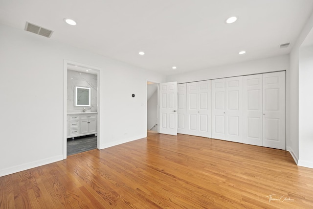 unfurnished bedroom with baseboards, light wood finished floors, visible vents, and recessed lighting