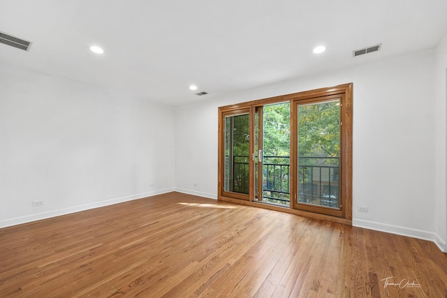 empty room with baseboards, visible vents, wood finished floors, and recessed lighting