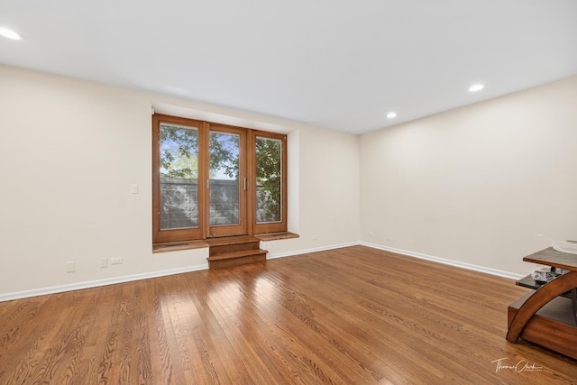 unfurnished living room featuring baseboards, wood finished floors, and recessed lighting