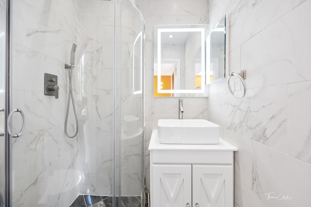 bathroom with a marble finish shower and vanity