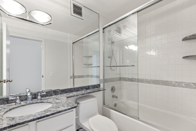 bathroom with visible vents, bath / shower combo with glass door, vanity, and toilet