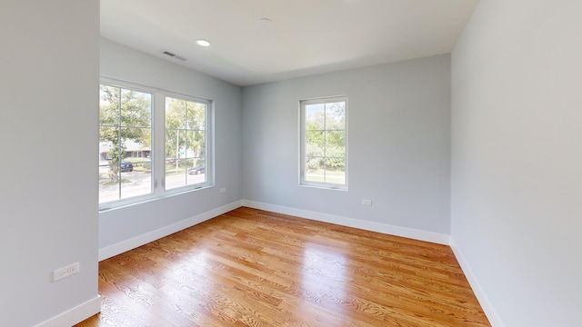 unfurnished room with light wood-style floors, baseboards, and visible vents