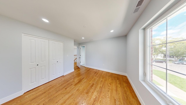 unfurnished bedroom featuring light wood-style flooring, recessed lighting, visible vents, baseboards, and a closet