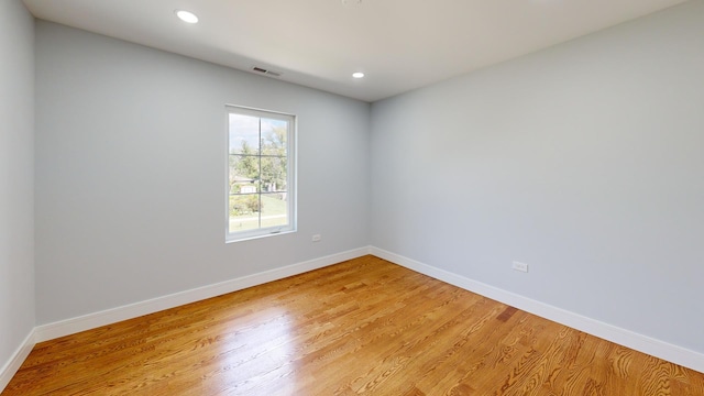 unfurnished room featuring light wood-type flooring, visible vents, baseboards, and recessed lighting