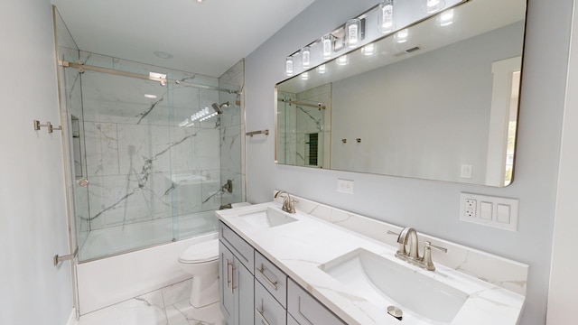 full bathroom featuring toilet, marble finish floor, shower / bath combination with glass door, and a sink