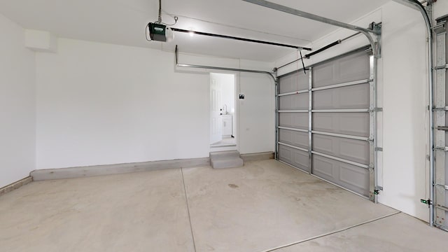 garage featuring a garage door opener and baseboards