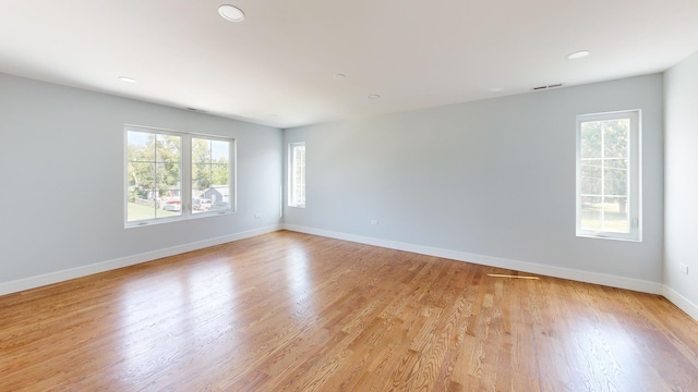 empty room featuring recessed lighting, light wood-type flooring, visible vents, and baseboards