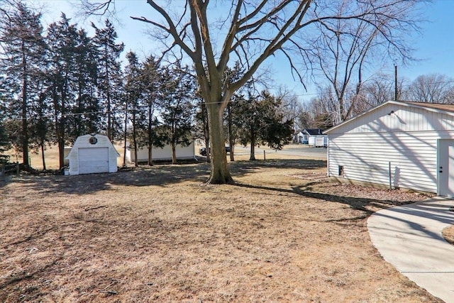 view of yard featuring an outbuilding, a detached garage, and a storage unit