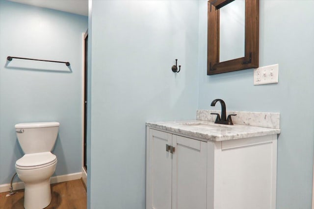 full bathroom with baseboards, toilet, wood finished floors, vanity, and a shower stall