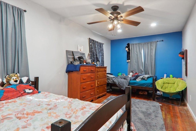 bedroom featuring ceiling fan, wood finished floors, and baseboards