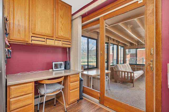 home office with built in study area and wood finished floors