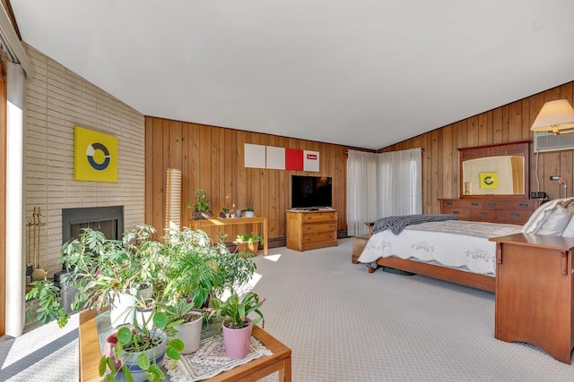 bedroom with lofted ceiling, baseboard heating, a brick fireplace, light carpet, and wooden walls