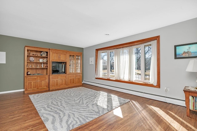 living area with baseboards, a baseboard heating unit, and wood finished floors