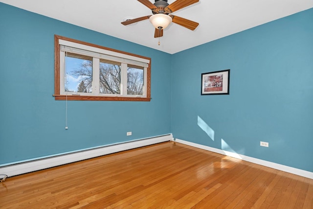 spare room with ceiling fan, a baseboard radiator, wood-type flooring, and baseboards